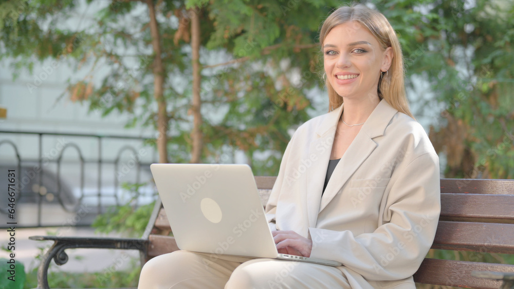 Young Business Lady Smiling at Camera while Working on Laptop Outdoor Young Business Lady Smiling at Camera while Working on Laptop Outdoor