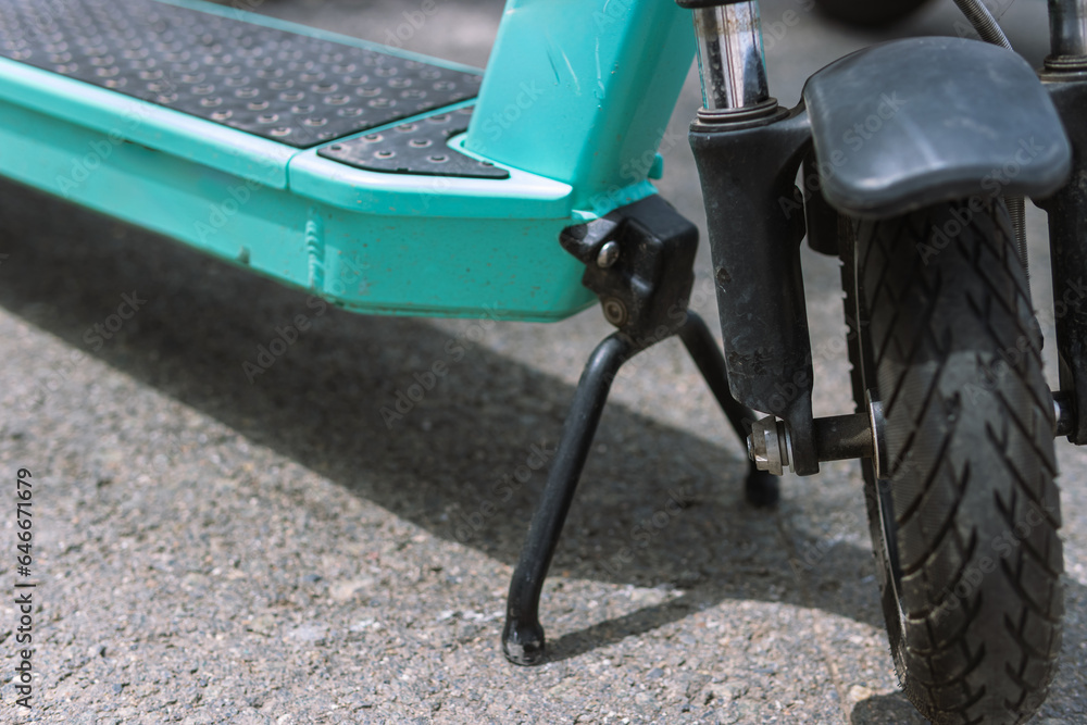 Fototapeta premium electric scooter close-up of the front wheel, the scooter stands on the leg on the street