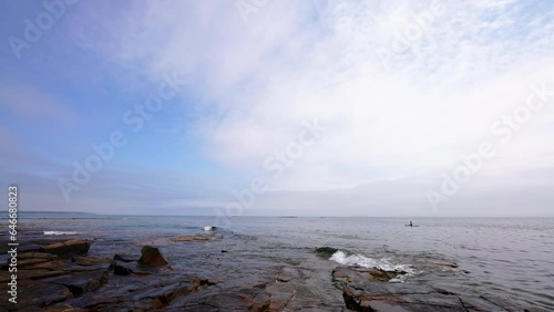 extra wide shot of a kayaker floating along the Atlantic coastline