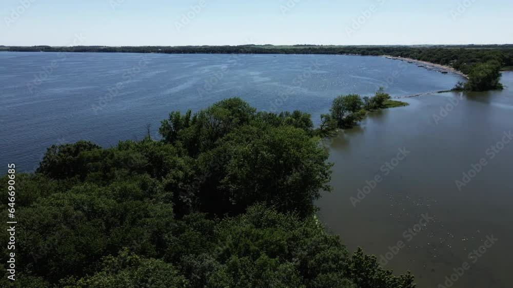 Aerial parallax of blue midwestern lake in Iowa. Flying over trees along the shore of Spirit Lake, IA. Aerial parallax of blue midwestern lake in Iowa. Flying over trees along the shore of Spirit Lake, IA.