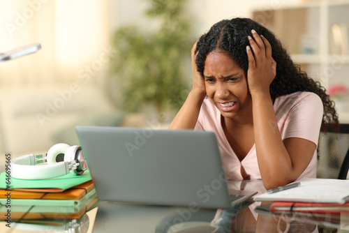 Overwhelmed black student complaining using laptop