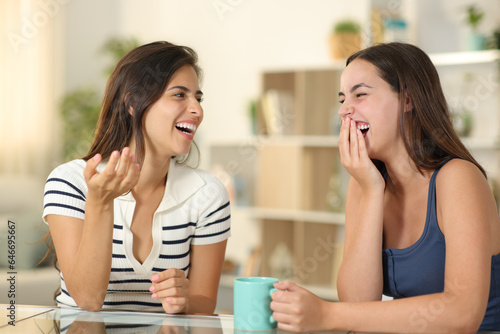 Happy woman laughing on conversation covering mouth