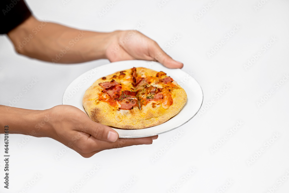 A human hand holding pizza on a plate
