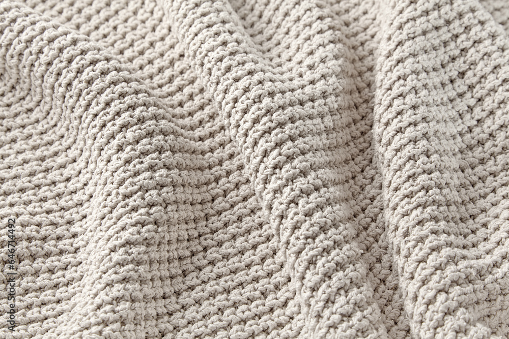 The texture of a large knitted gray sweater folded in waves. High quality background for design and layout The texture of a large knitted gray sweater folded in waves. High quality background for design and layout