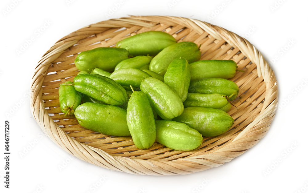 green bilimbi kamias fruit in bamboo plate isolated on white background. pile of green bilimbi kamias fruit isolated. heap of green bilimbi kamias fruit isolated                               