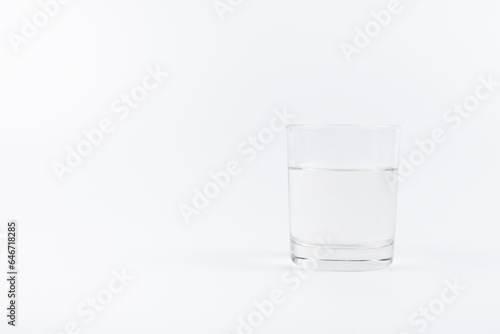 A glass of water on the table. On a white background.