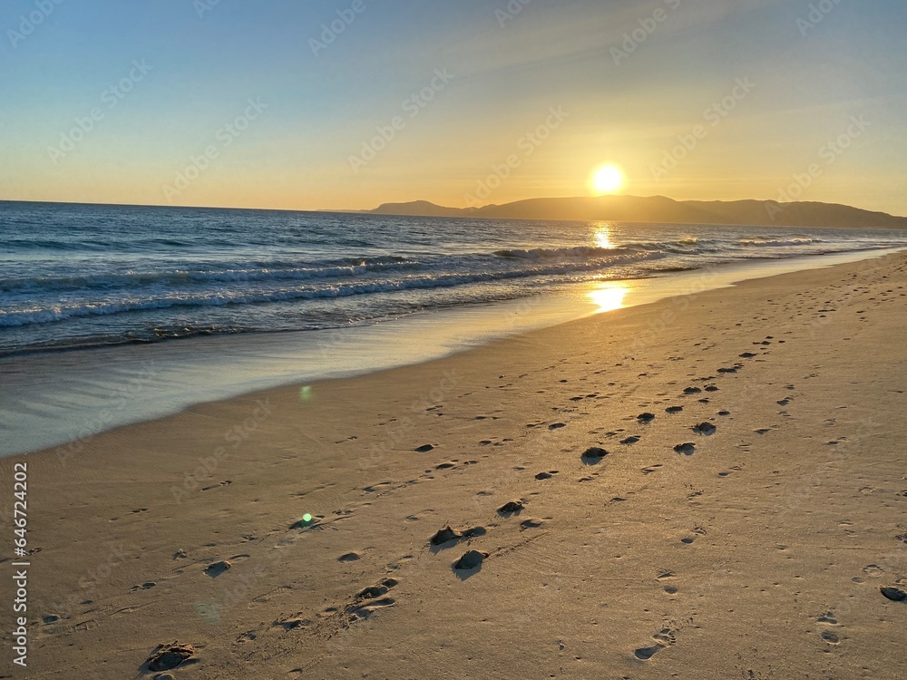 Sunset at the beach with footprints in sand Sunset at the beach with footprints in sand