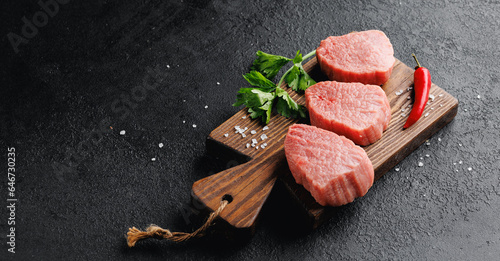 Raw Steak Fresh meat veal fillet on wooden board, dark background top view photo