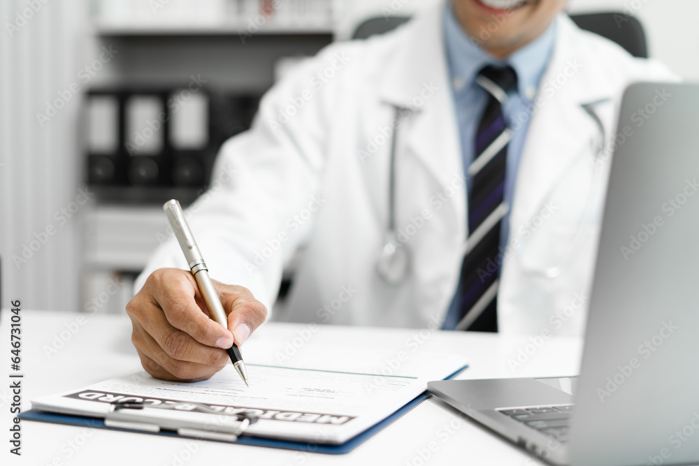 Doctor working on laptop computer and tablet and medical stethoscope on clipboard on desk, electronics medical record system EMRs concept. Doctor working on laptop computer and tablet and medical stethoscope on clipboard on desk, electronics medical record system EMRs concept.