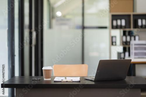 workspace area with laptop tablet smartphone and paperwork on the table in the office concept. © NINENII