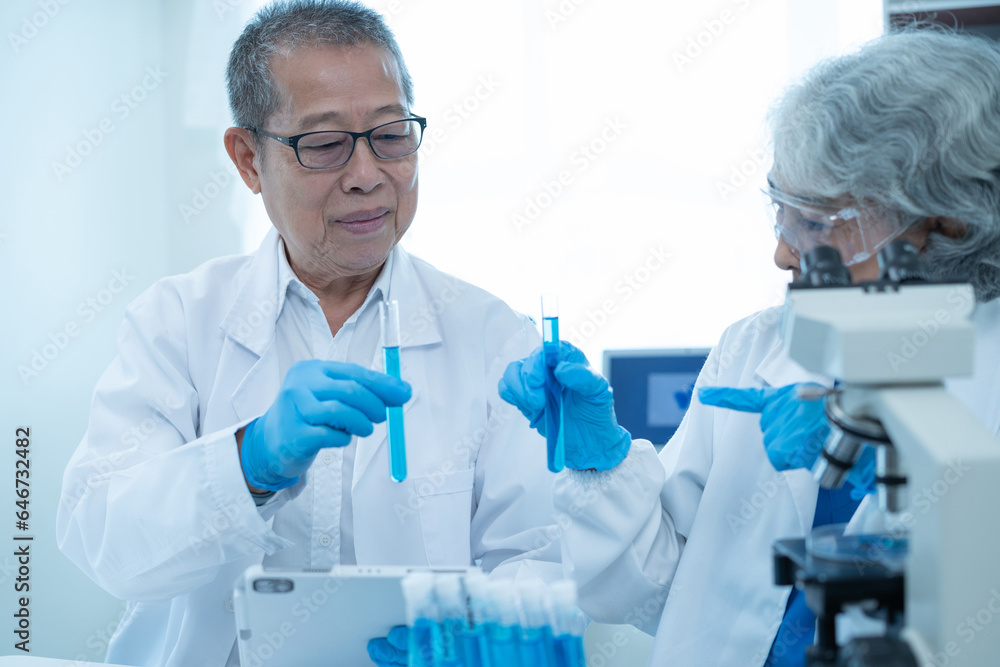Medical Research Laboratory: Two scientists working, using digital tablets, analyzing samples, talking, developing biotechnology. Medical Research Laboratory: Two scientists working, using digital tablets, analyzing samples, talking, developing biotechnology.