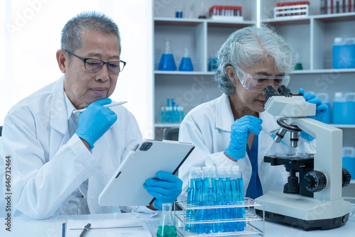 Medical Research Laboratory  Two scientists working  using digital tablets  analyzing samples  talking  developing biotechnology.