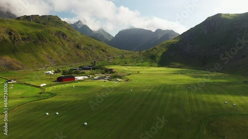 Aerial Footage of Vik Beach and Hauklandstranda Norway, drone of farmland with hay bails rolled up in the mountain valley photo