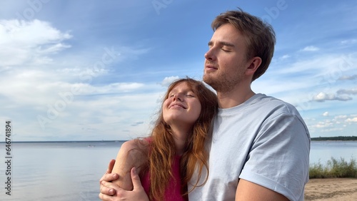 Happy couple in love hug each other, walk on natural background at summer day 