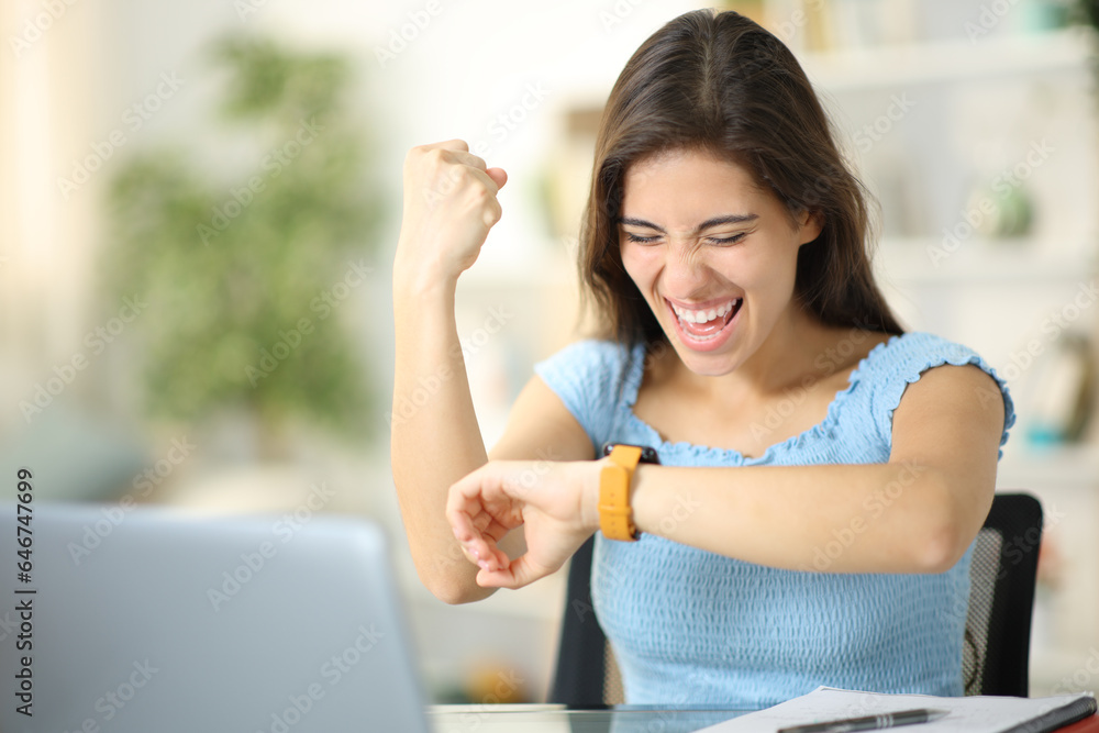 Excited student cheking smartwatch at home