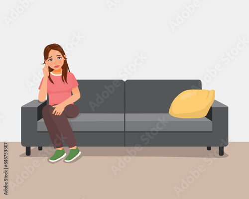 Young woman feeling sad and lonely sitting on couch at home