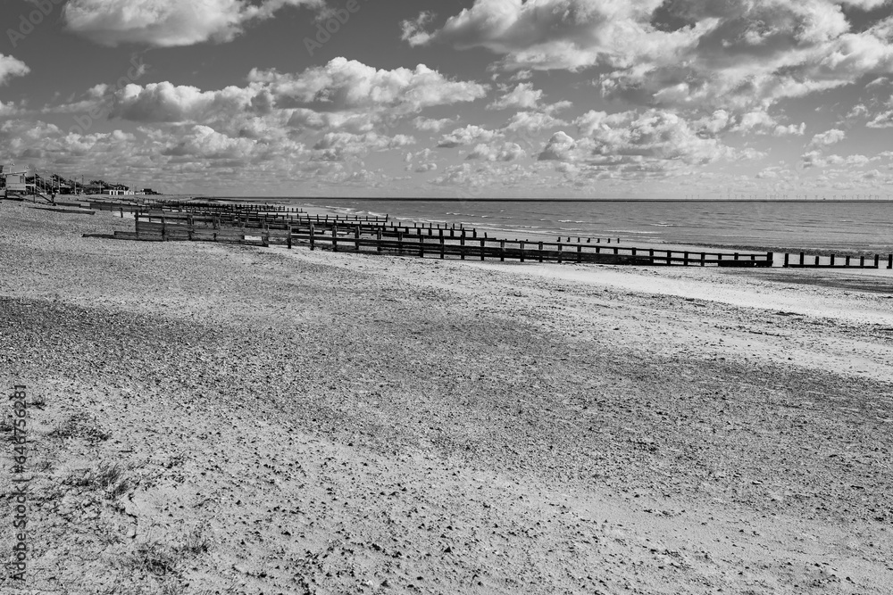 Clouded sky over Littlehampton Beach in Sussex, England, UK in black and white