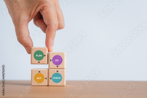 For continuous quality improvement model of four key stages (Plan, Do, Check, Action or PDCA), efficiency concept. Solving problems, improving organization  process. Hand completed wooden cube blocks