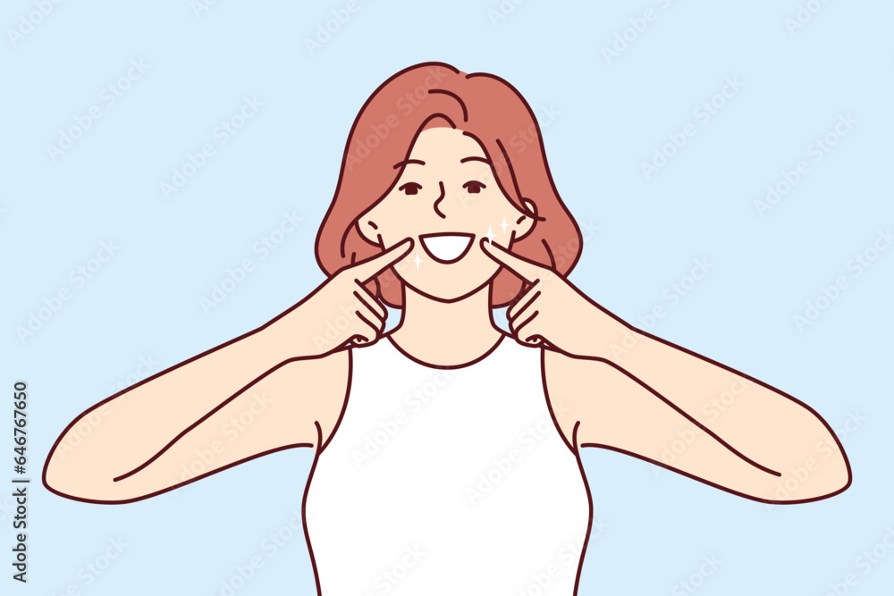 Woman smile and shows off white teeth and points fingers at mouth to invite people to dental clinic. Positive girl is trained to make big smile to appear friendly for successful sales Woman smile and shows off white teeth and points fingers at mouth to invite people to dental clinic. Positive girl is trained to make big smile to appear friendly for successful sales