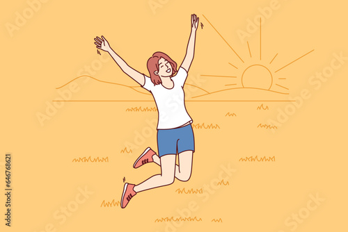 Happy woman jumping walking in summer field with grass and enjoying beautiful natural scenery with sunset. Girl has fun by going to countryside and enjoying freedom or absence of people around
