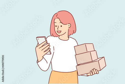 Woman holds phone and cardboard boxes delivered by courier from online store or post office