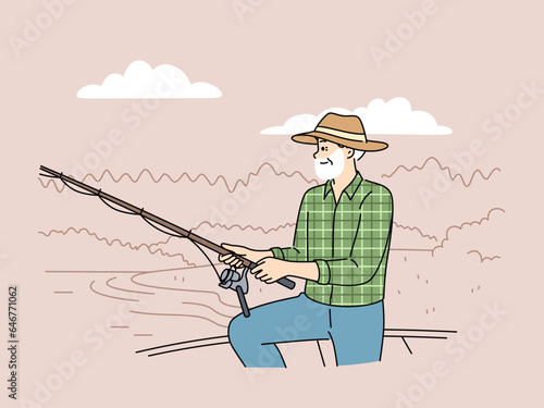 Elderly fisherman fishes, standing on boat or on dock near lake and feels full of energy after retirement. Old man fisherman with fishing rod in hands enjoying favorite hobby and good summer weather