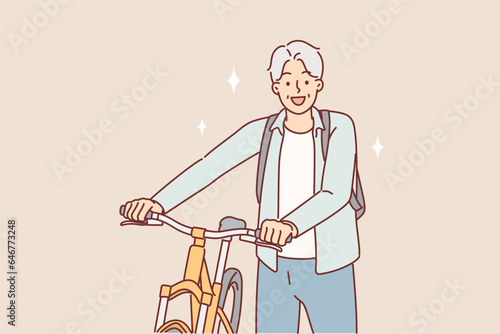 Elderly man cyclist stands near bicycle and looks at screen smiling while cycling through park