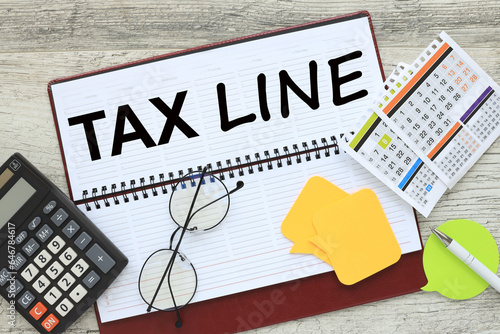 tax line. notepad with text near calculator and calendar