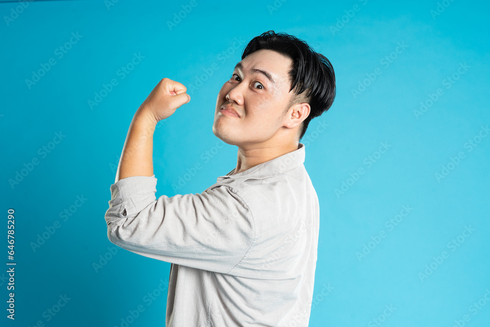 Portrait of an Asian guy posing on a blue background Portrait of an Asian guy posing on a blue background