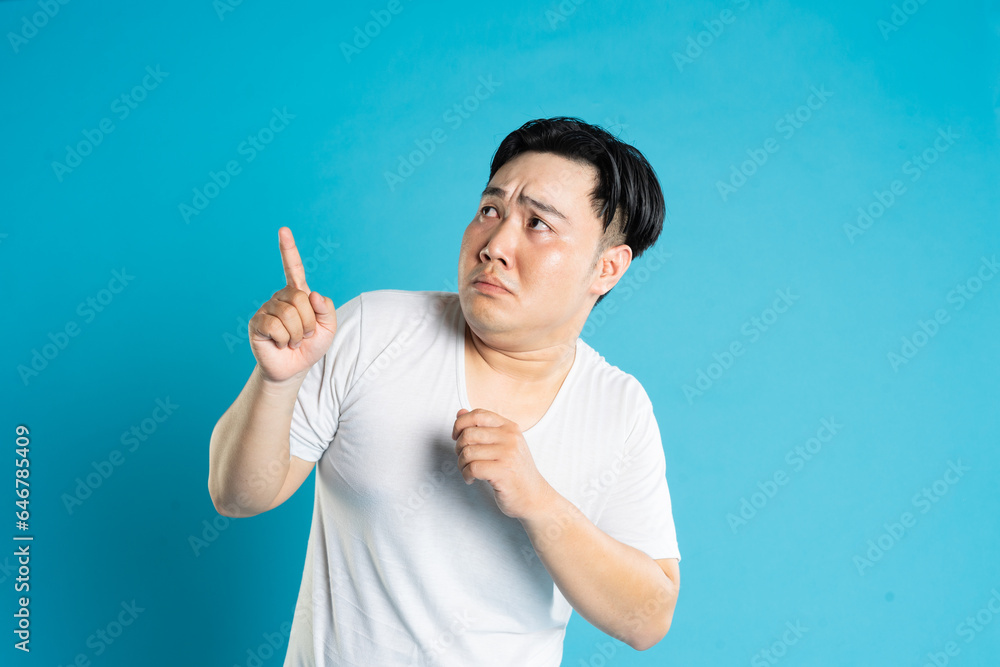 Portrait of an Asian guy posing on a blue background Portrait of an Asian guy posing on a blue background