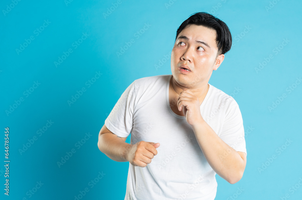 Portrait of an Asian guy posing on a blue background Portrait of an Asian guy posing on a blue background