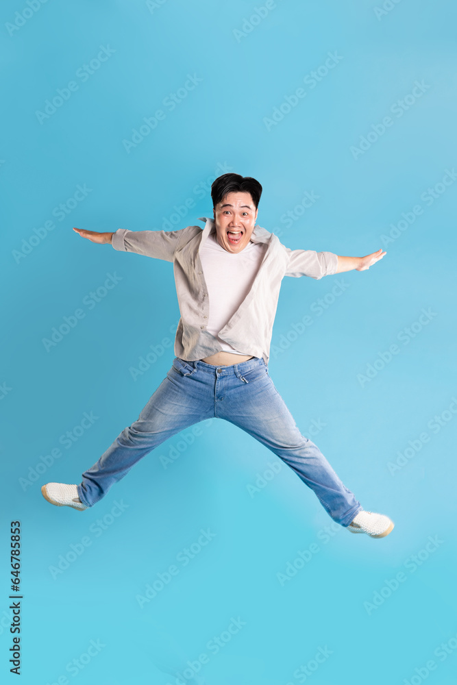 Full body image of Asian man posing on blue background Full body image of Asian man posing on blue background