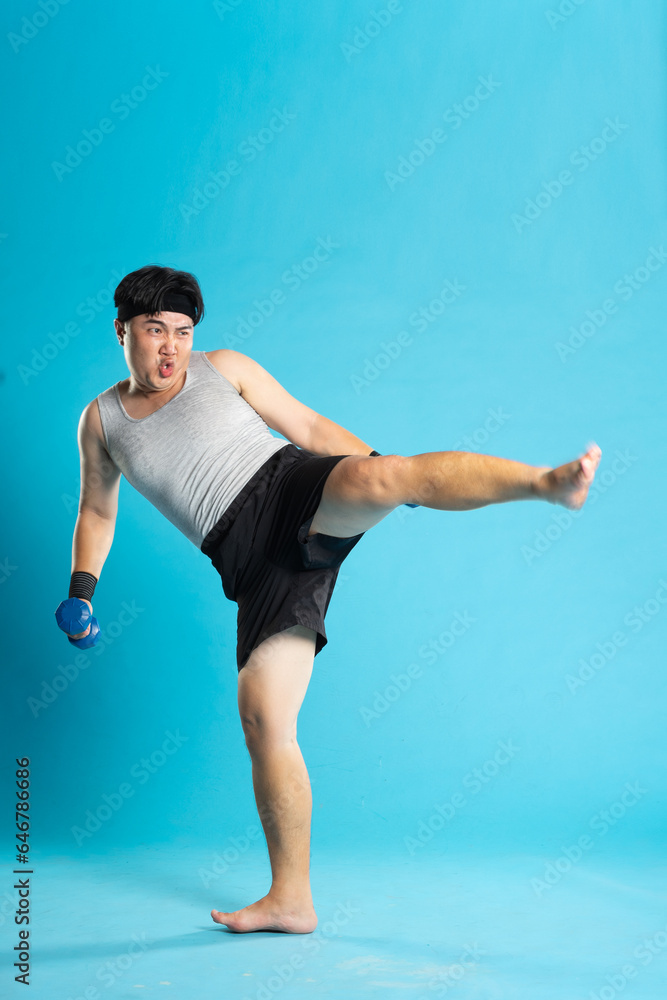Image of Asian man exercising on blue background Image of Asian man exercising on blue background