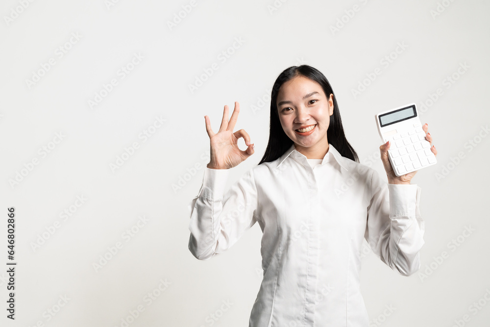 Young woman isolated on white background showing ok sign with calculator Young woman isolated on white background showing ok sign with calculator
