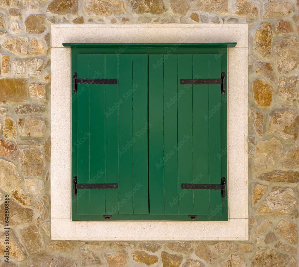 Wooden shutters on the window against the background of a stone wall. Wooden shutters on the window against the background of a stone wall.