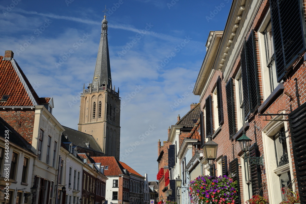 Traditional historic medieval houses in the old picturesque town of Doesburg, Gelderland, Netherlands, with the bell tower of Martinikerk church 