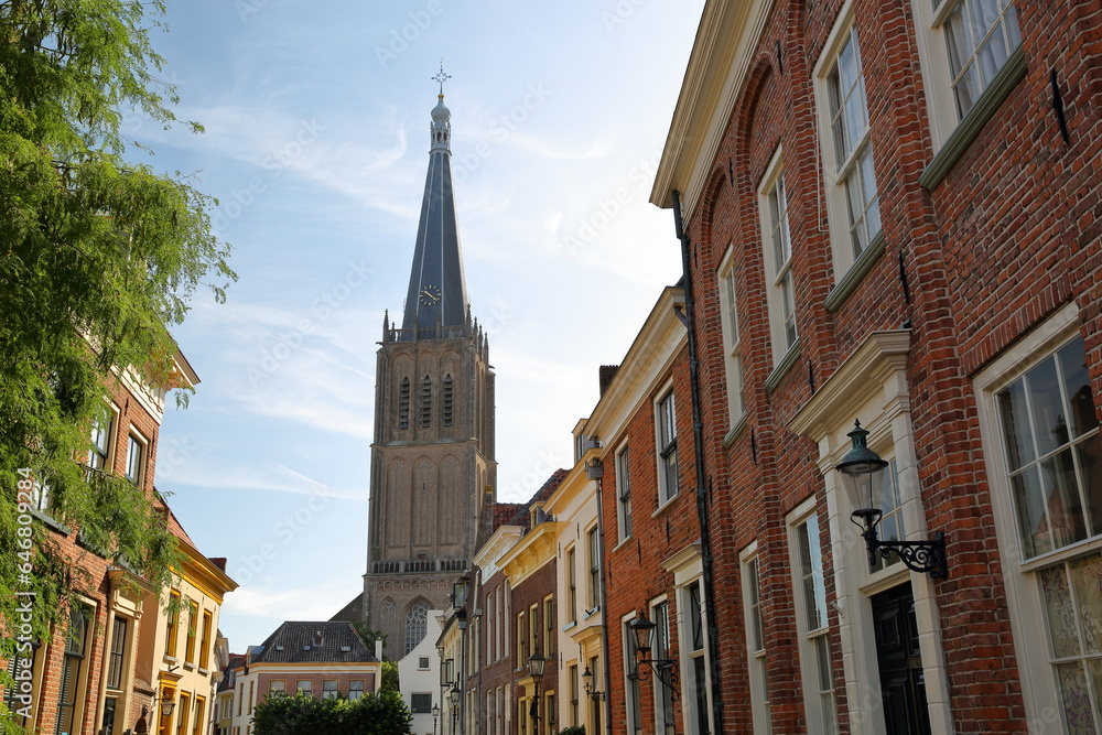 Traditional historic medieval houses in the old picturesque town of Doesburg, Gelderland, Netherlands, with the bell tower of Martinikerk church 