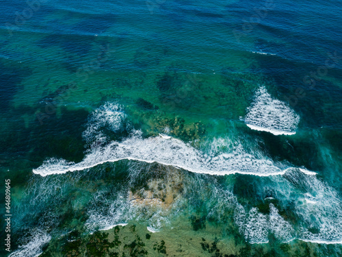 blue green ocean water with waves incoming to shore - aerial overhead view photo