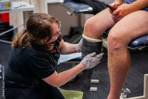 medical professional putting walking cast on leg