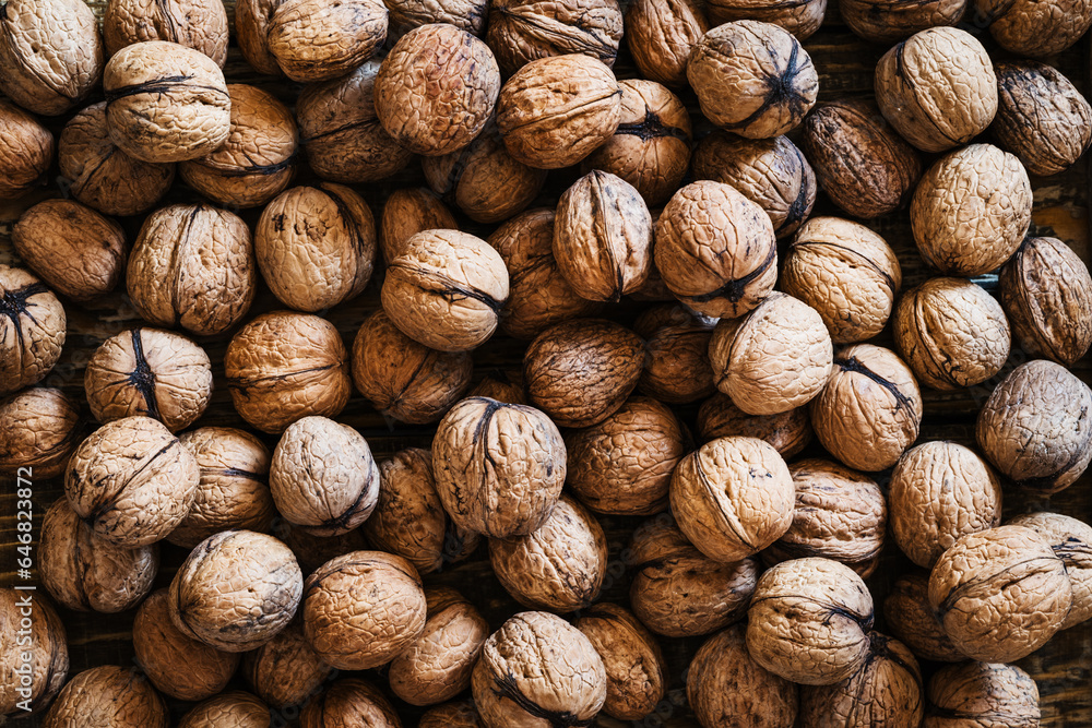 Organic walnuts on wooden table, autumn harvest time full frame, top view close up Organic walnuts on wooden table, autumn harvest time full frame, top view close up