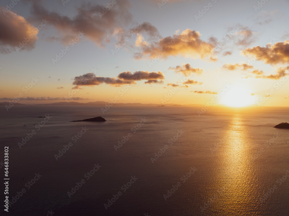 Aerial sunset view of Langford Island, Whitsunday Islands, Queensland, Australia, near Great Barrier Reef. Popular tourist destination near Hayman Island. Queensland mainland coast in the background.