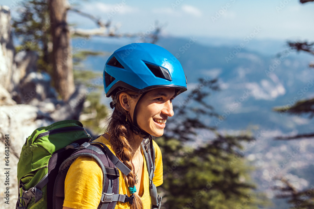 Portrait of a woman in a helmet for mountaineering and rock climbing against the backdrop of mountains. Safety in extreme sports. outdoor sports Portrait of a woman in a helmet for mountaineering and rock climbing against the backdrop of mountains. Safety in extreme sports. outdoor sports