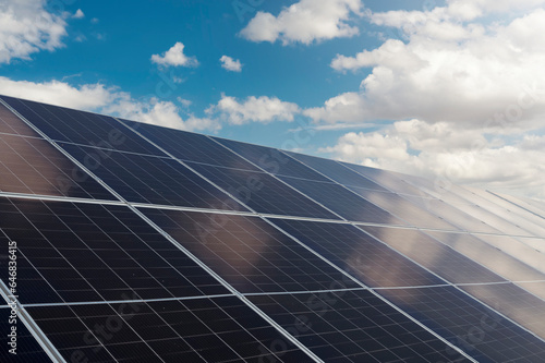 Large solar panels in an open field during sunny summer day