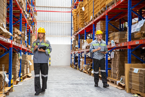 Warehouse workers checking the inventory. Products on inventory shelves storage. Worker Doing Inventory in Warehouse. Dispatcher in uniform making inventory in storehouse. supply chain concept	
