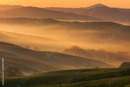 Beautiful hills covered by the fog in Tuscany at sunrise
