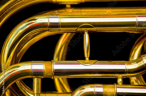 close-up of t a gold-colored pump-action trumpet on a black background