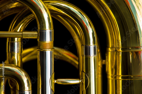 close-up of t a gold-colored pump-action trumpet on a black background