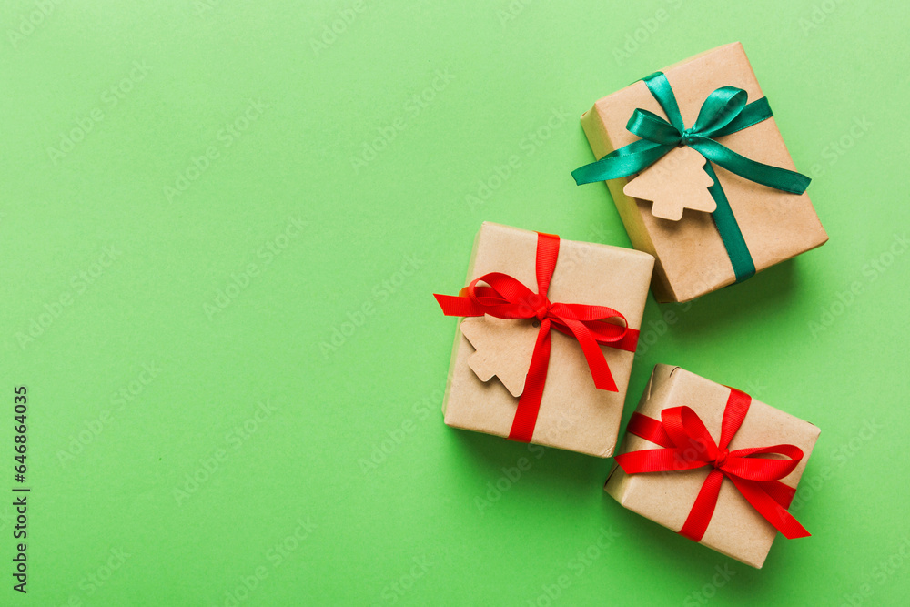 wrapped christmas or other holiday handmade present in paper with colored ribbon. Present box, decoration of gift on colourfull table, top view with copy space wrapped christmas or other holiday handmade present in paper with colored ribbon. Present box, decoration of gift on colourfull table, top view with copy space