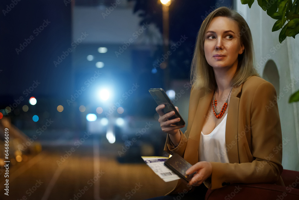 © M-Production - Woman with passport and plane ticket in the waiting area. © M-Production - Woman with passport and plane ticket in the waiting area.
