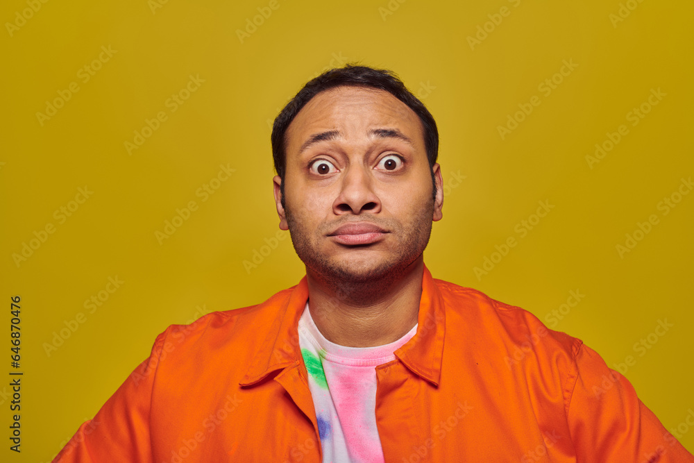 shocked indian man with eyes wide open looking at camera isolated on yellow, face expression shocked indian man with eyes wide open looking at camera isolated on yellow, face expression